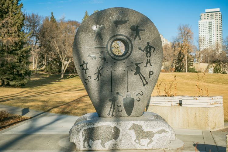 Photo of the Rock Grandfather side of the residential school monument, with petroglyphs depicting the symbolic effect of residential schools.