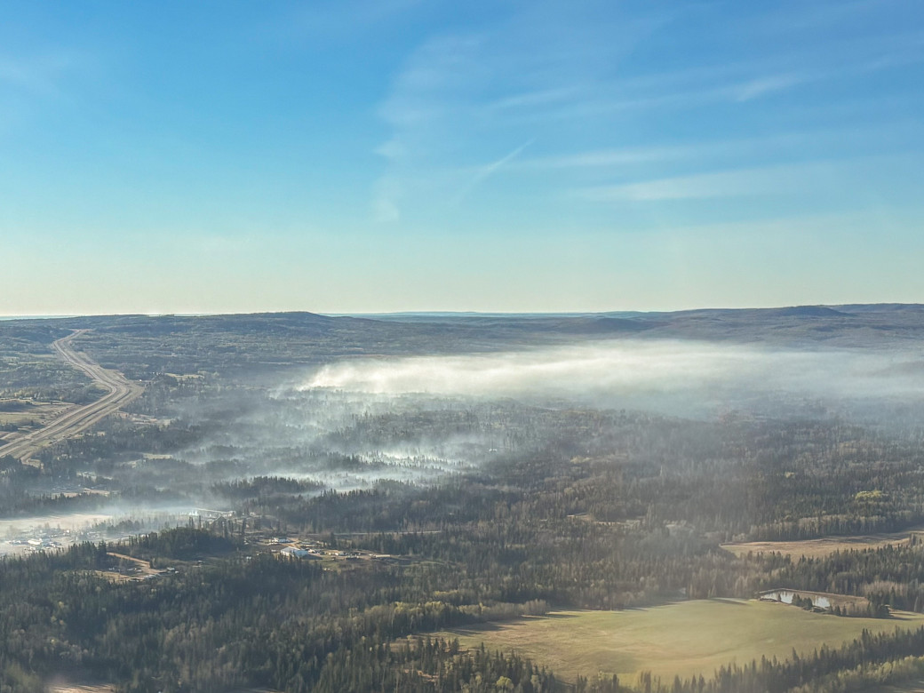 Smoke settles over a wildfire in the morning.