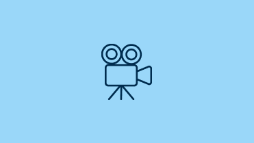 Icon of a vintage film camera with reels on a tripod.