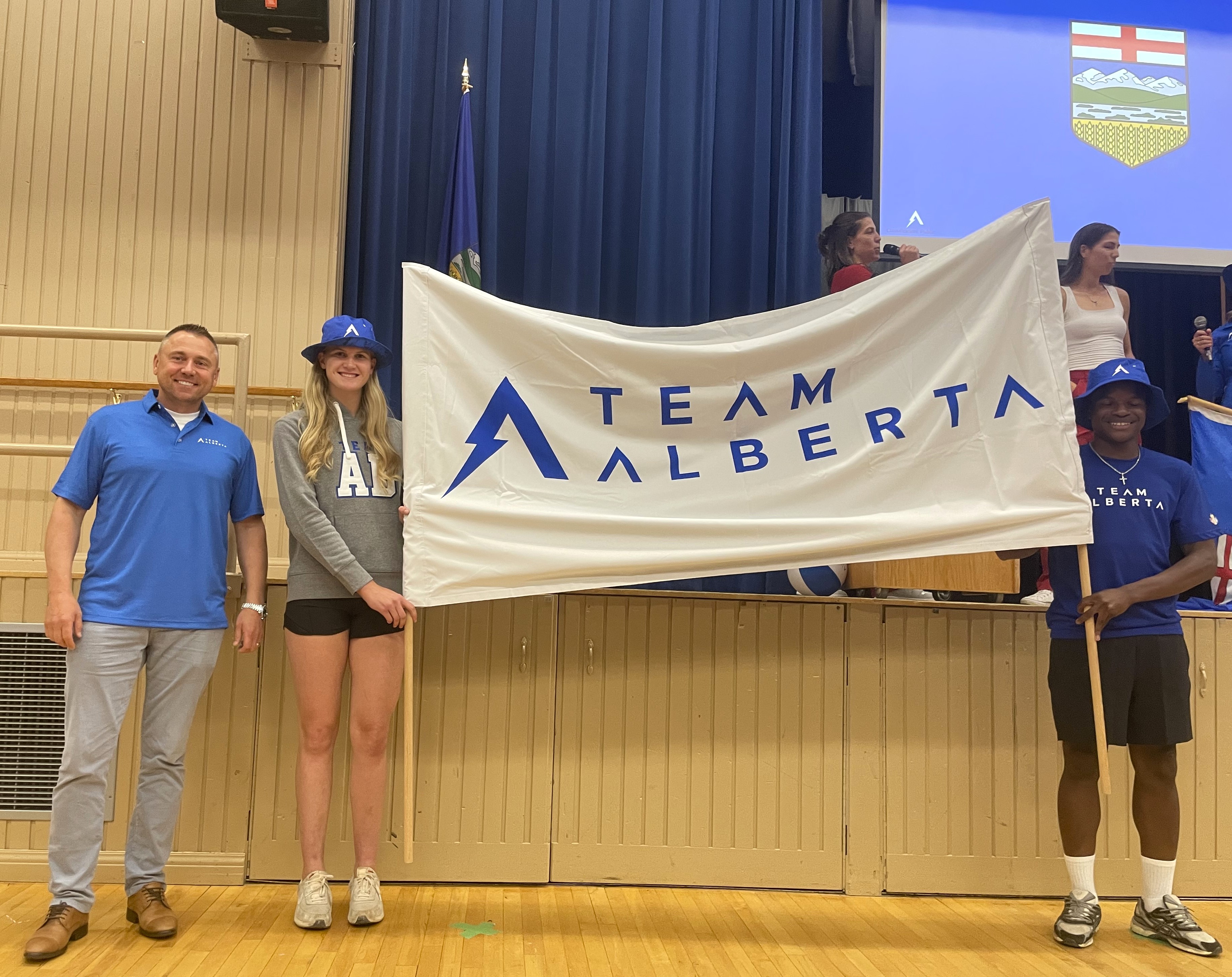 Minister of Tourism and Sport, Andrew Boitchenko next to Team Alberta’s banner carriers, Katherine Thiessen of Lloydminster (softball) and Ethan Darpoh of Edmonton (soccer).