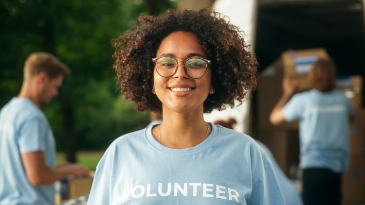 Image of a smiling woman with a volunteer t-shirt
