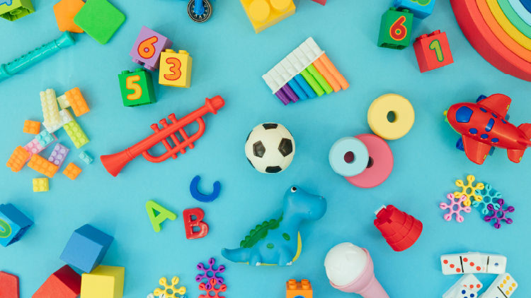 Various toys such as building blocks, lego pieces soccer ball, toy airplane on a light blue background