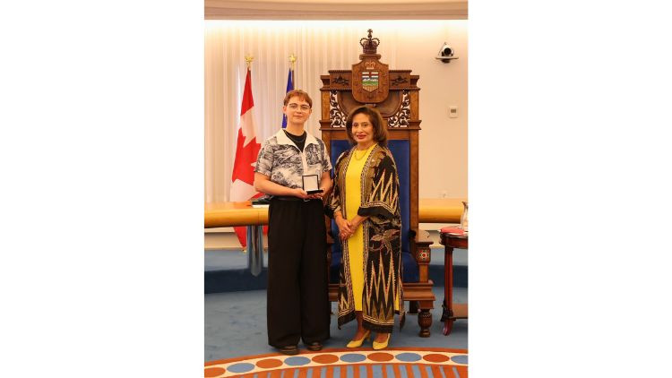 Award recipient Aryana Sophia (Ary) Ki-Michaels receives a medal during a presentation ceremony in the Alberta Legislature chamber.