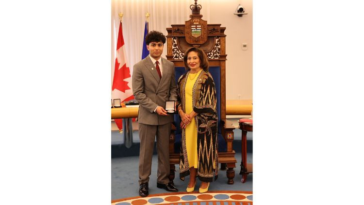 Award recipient Kamran Shukoor receives a medal during a presentation ceremony in the Alberta Legislature chamber.