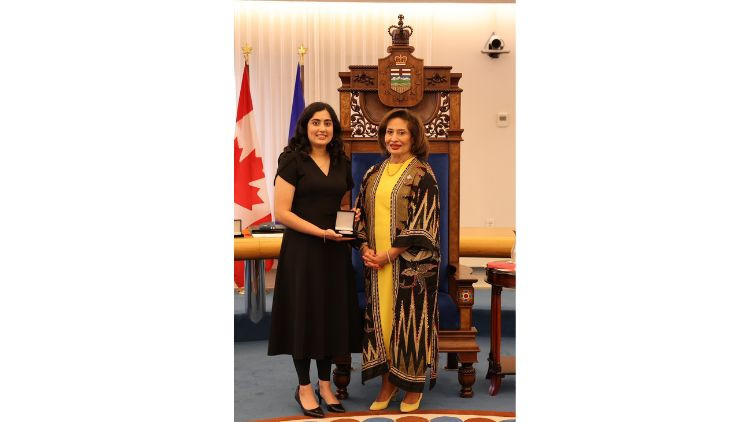 Award recipient Fatema Riaz receives a medal during a presentation ceremony in the Alberta Legislature chamber.