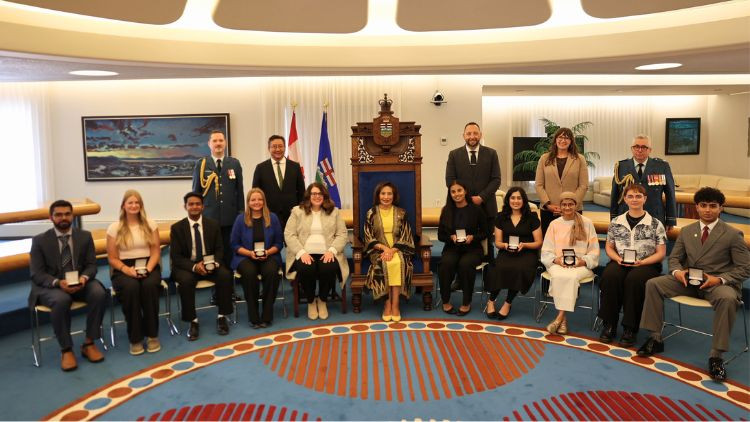Award presentation ceremony in a formal chamber with MLAs, the Lieutenant Governor of Alberta and the award recipients.
