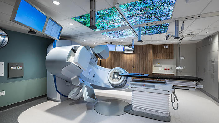 Medical equipment in a room with computer monitors and a ceiling mural