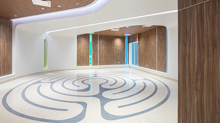 Calgary Cancer Centre interior - white walls with wood paneling and a mural on the floor