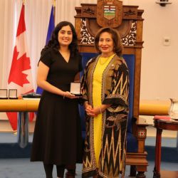 Award recipient Fatema Riaz receives a medal during a presentation ceremony in the Alberta Legislature chamber.