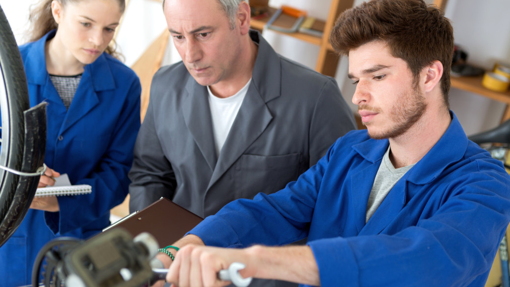 Apprentices working on a project while an instructor looks on