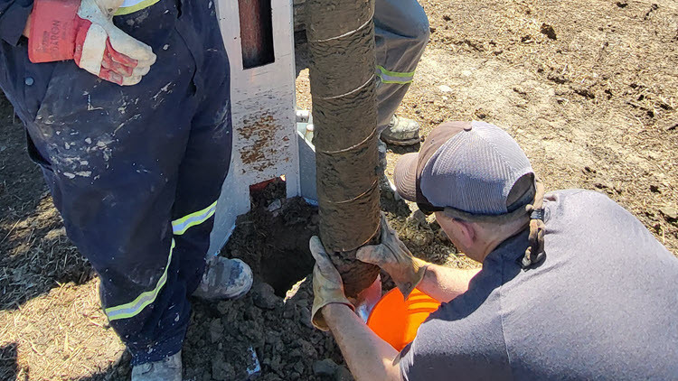 People directing a large drill in the ground