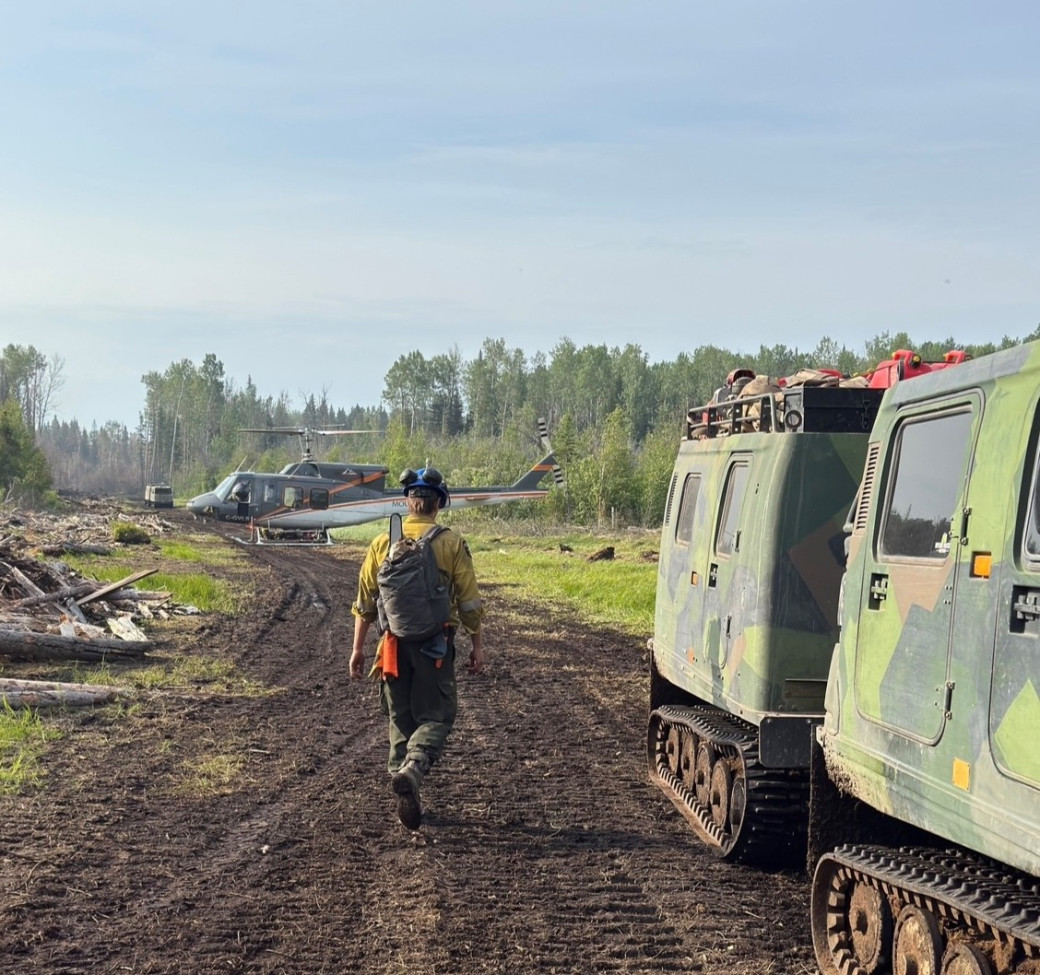 A medium helicopter and tracked vehicles transport firefighters into location on HWF036 (June 15, 2025)