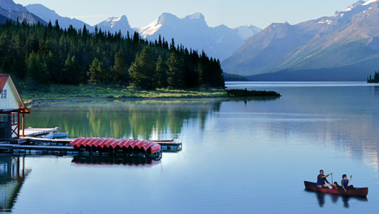 Photo of a lake in the mountains with people canoeing
