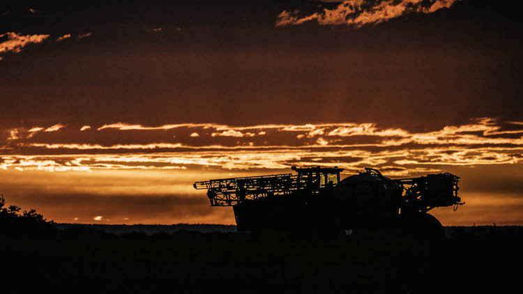 Farm Machiner in Field at Sunset