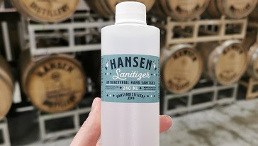 Bottle of Hansen Distillery Hand Sanitizer in person's hand