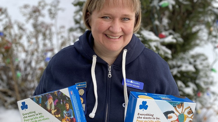 Image of Kathy House holding packages of Girl Guide cookies in each hand