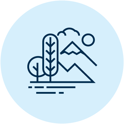 Trees and mountains under a sun and cloud