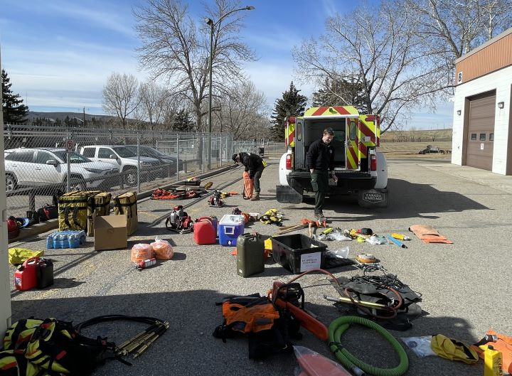 A group of wildland firefighters has gear laid out near their truck. to ensure inventory is complete.