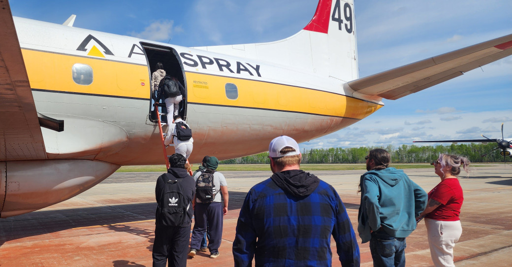 Students climb ladder into an airtanker at the High Level Airport on May 21