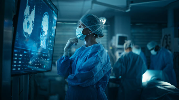 A doctor in scrubs examines an MRI scan.